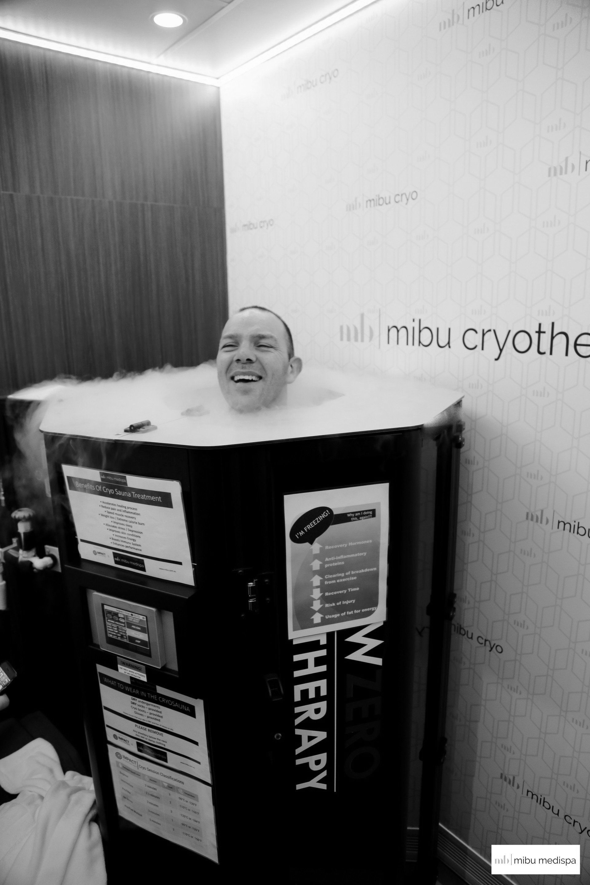 Man in a cryotherapy chamber, head visible above the fog.