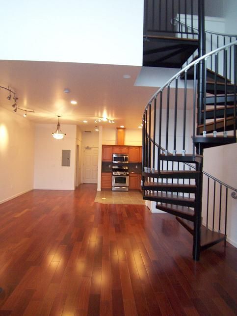 An empty room with a spiral staircase leading to the second floor