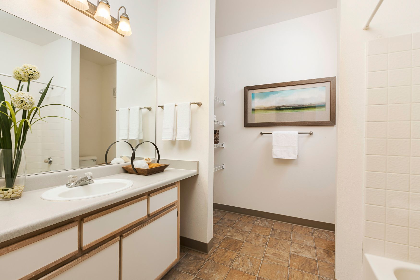A bathroom with a sink , mirror , and bathtub.