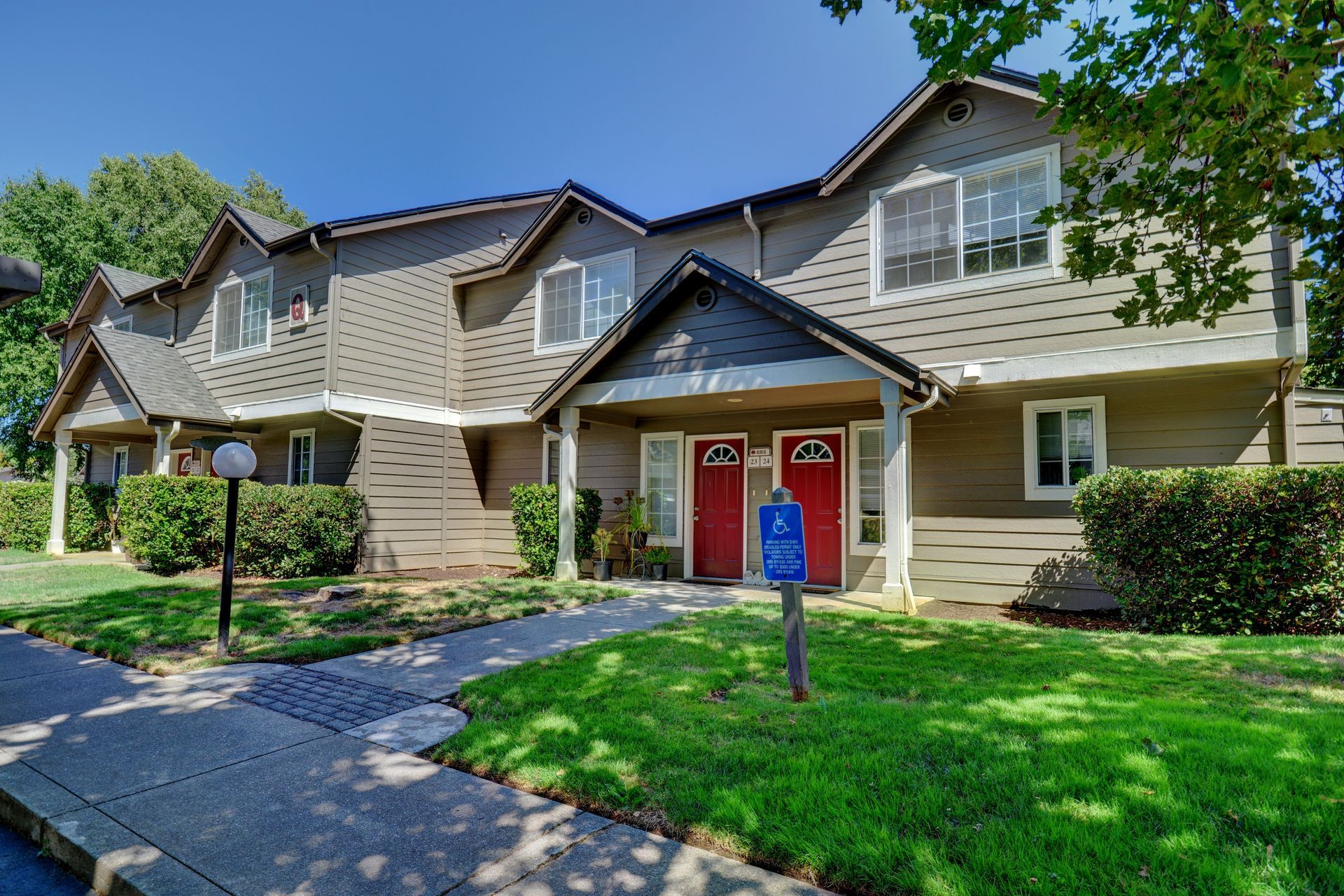 A house with two red doors and a blue mailbox in front of it