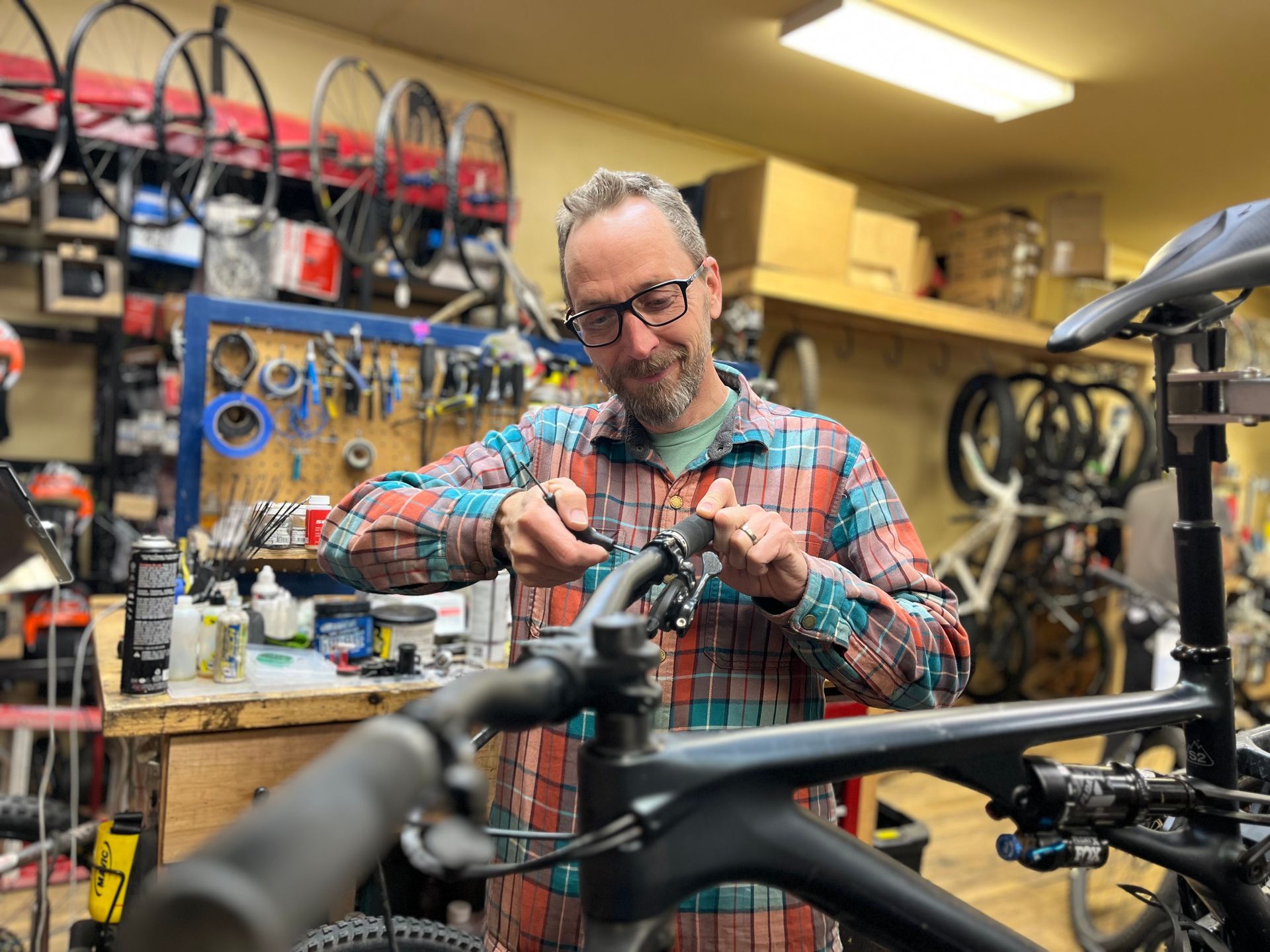 A man is working on a bicycle in a garage.