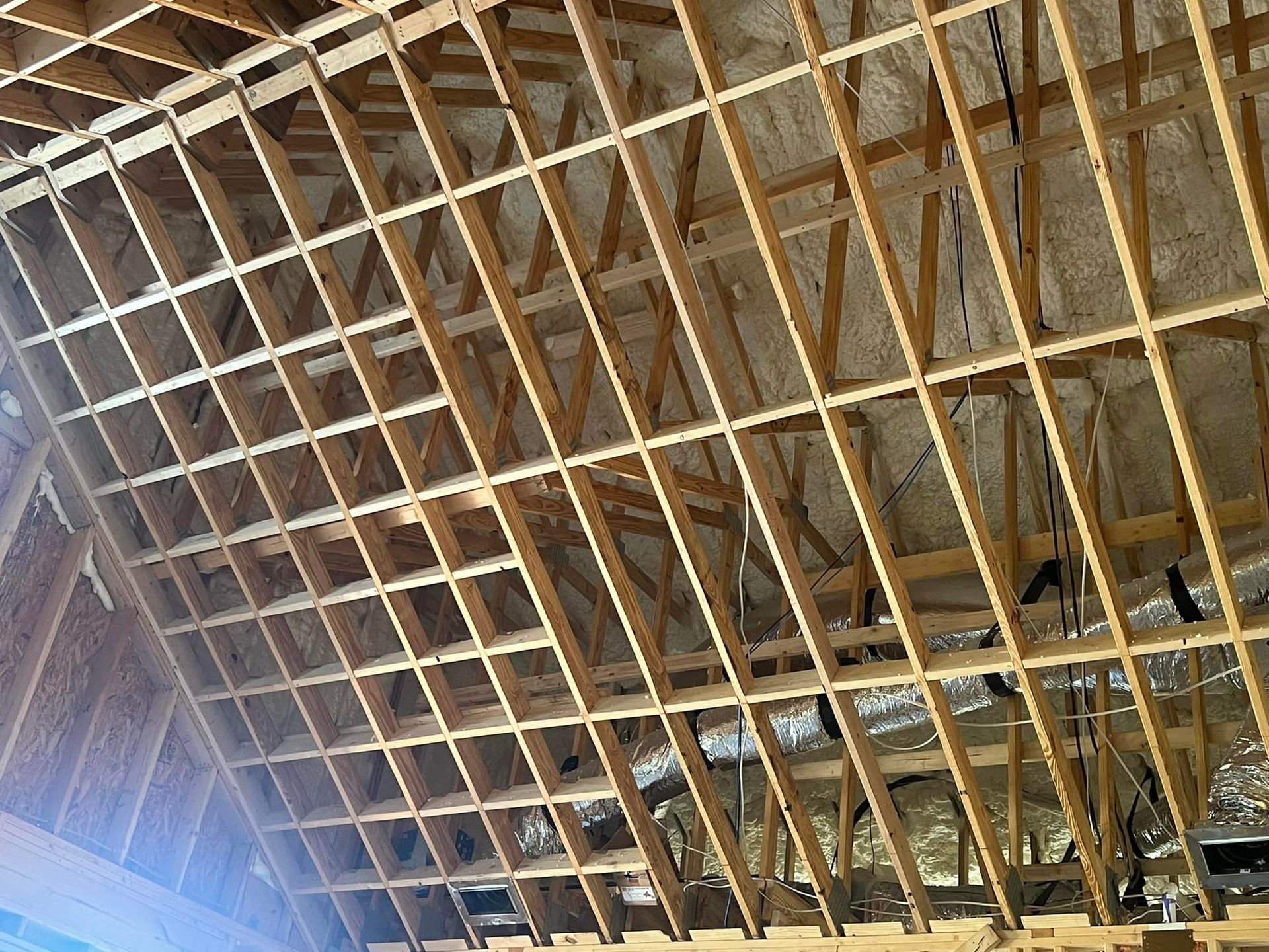 Wooden roof framework with insulation visible.