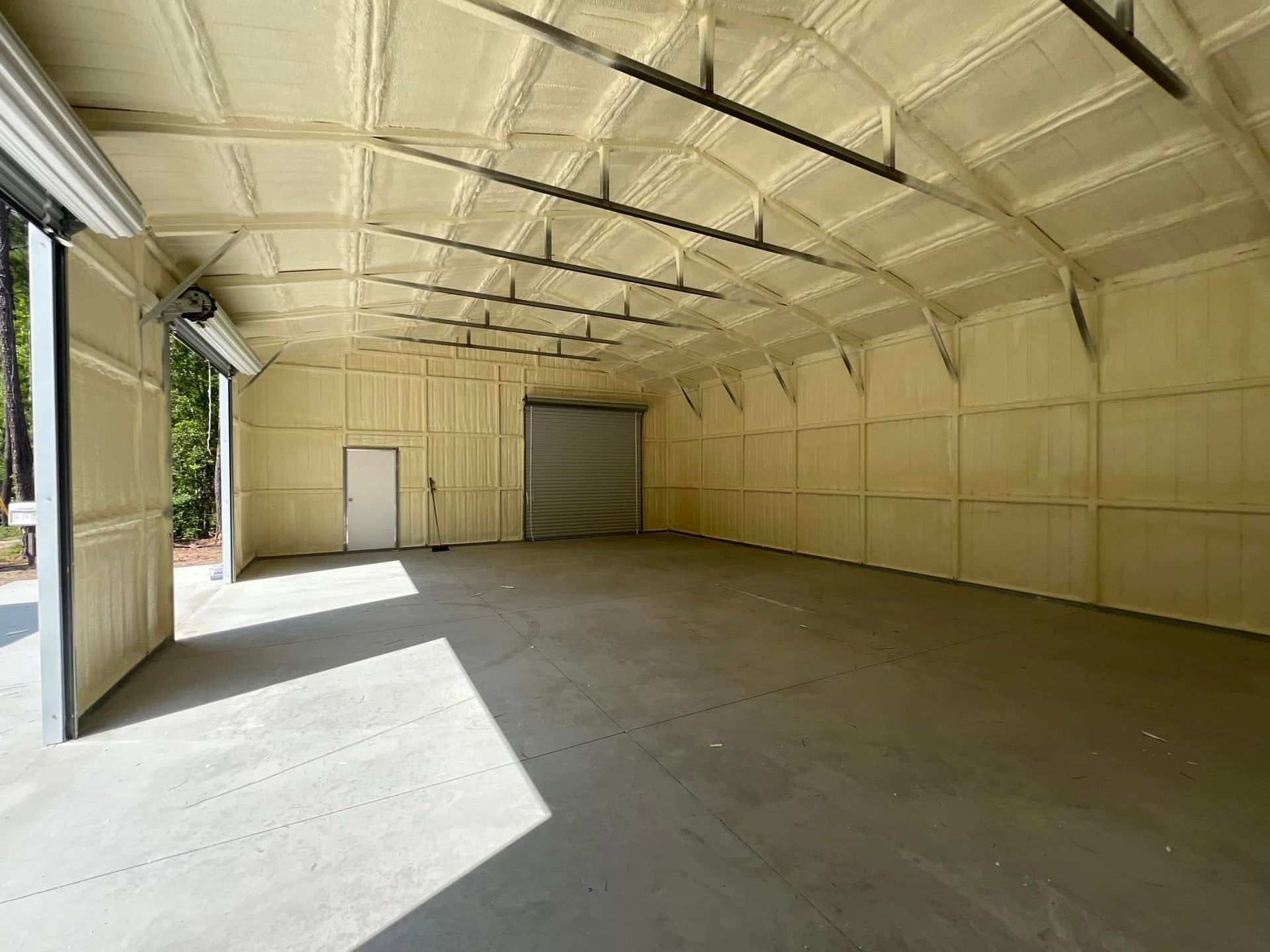 Interior of a warehouse with spray foam insulation on the walls and ceiling.