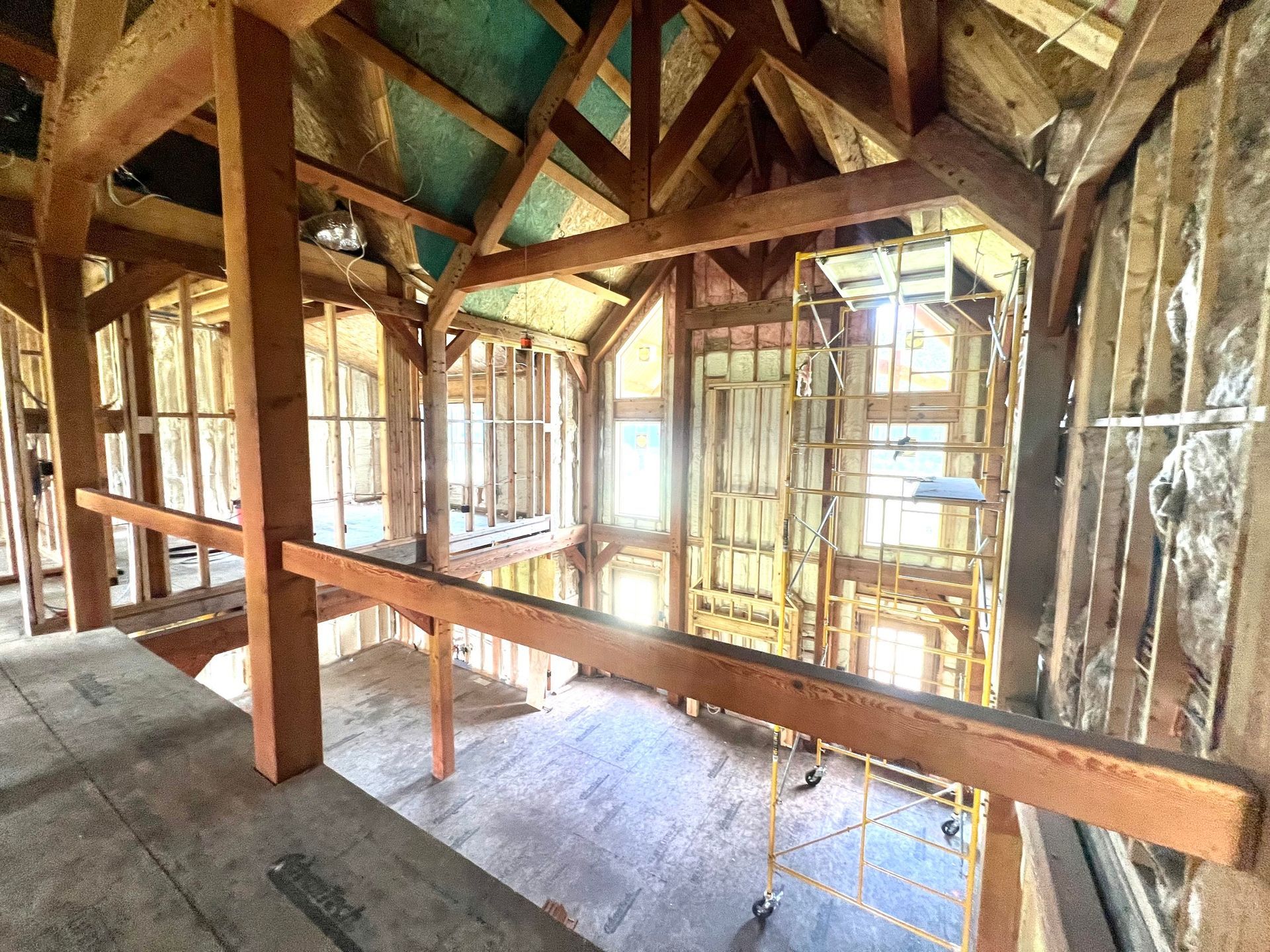 Interior of a building under construction, wooden beams and framing visible, unfinished.
