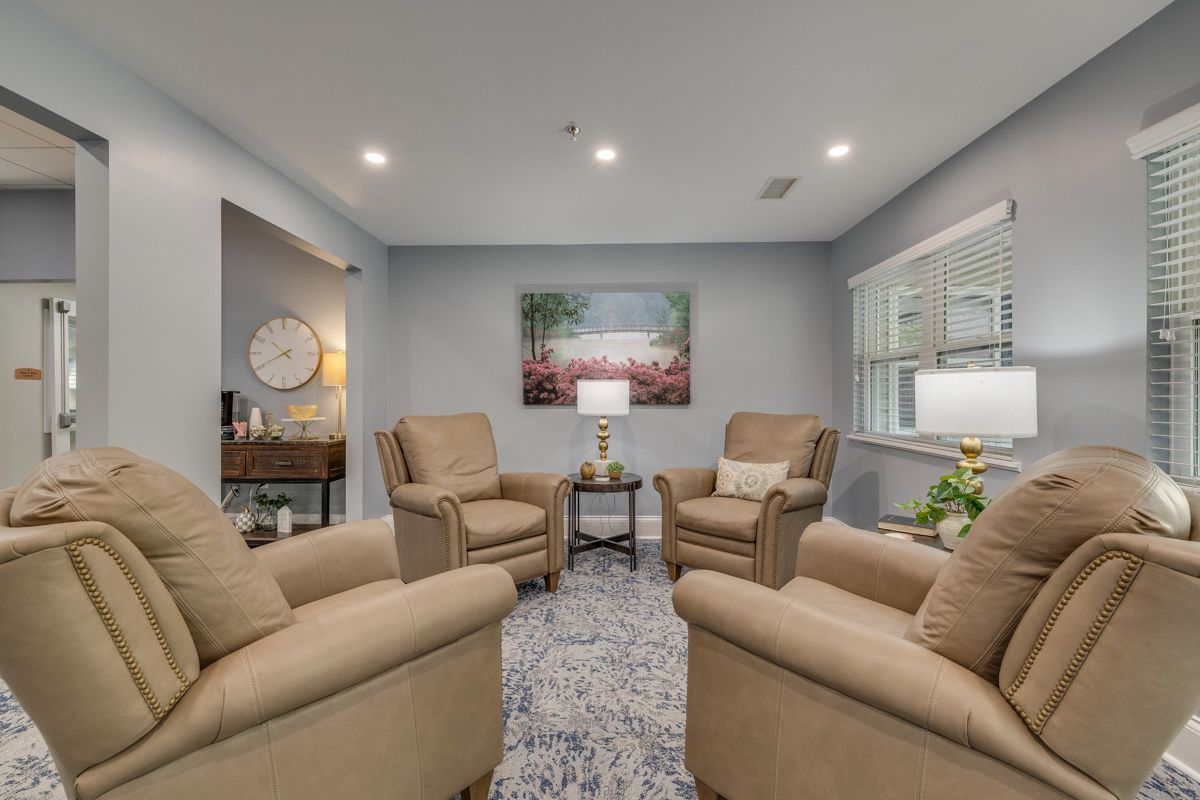 A living room filled with furniture and a clock on the wall.