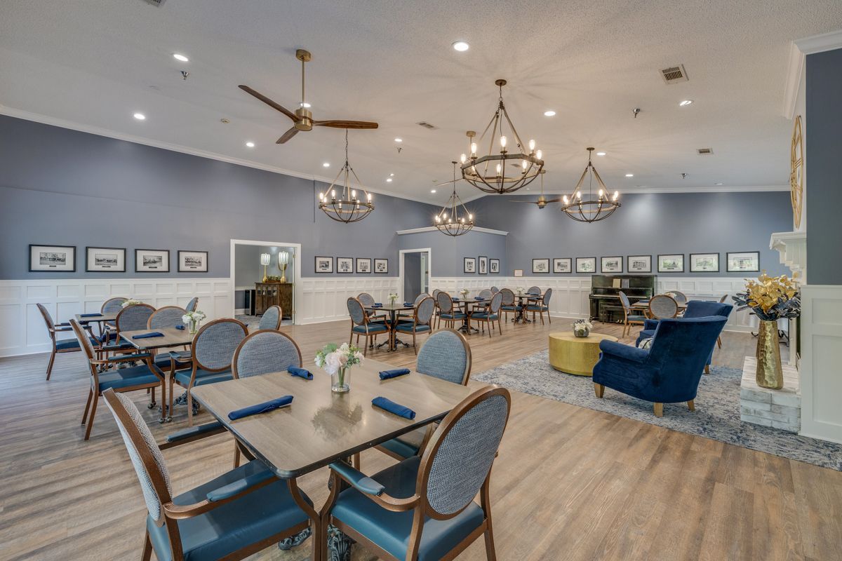 A large dining room with tables and chairs and a fireplace.