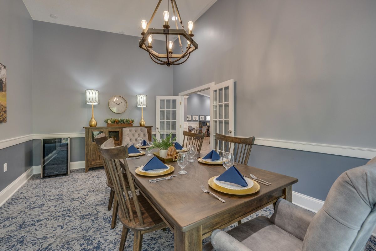 A dining room with a table and chairs and a chandelier.