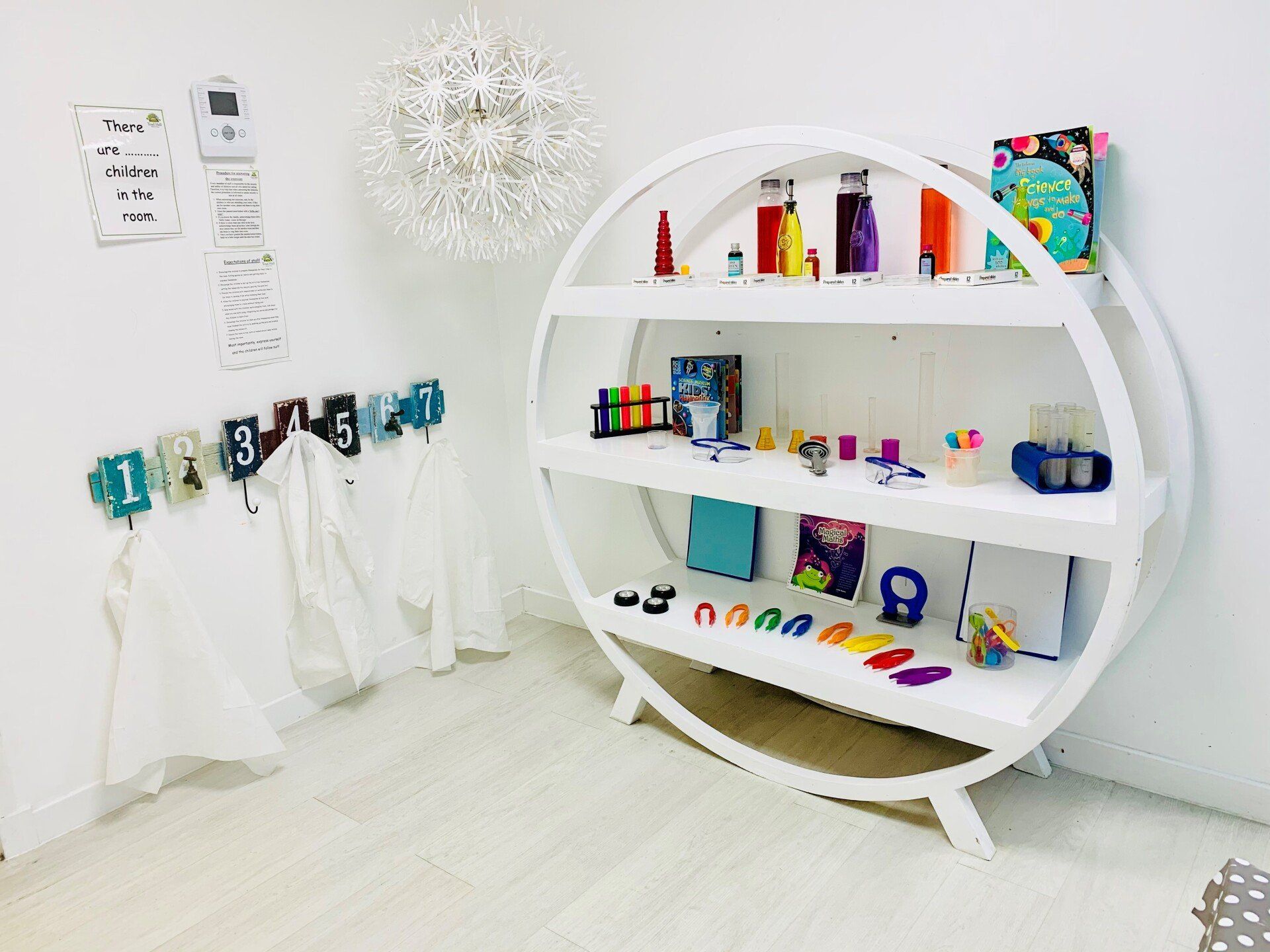 A room with a round shelf filled with toys and books.