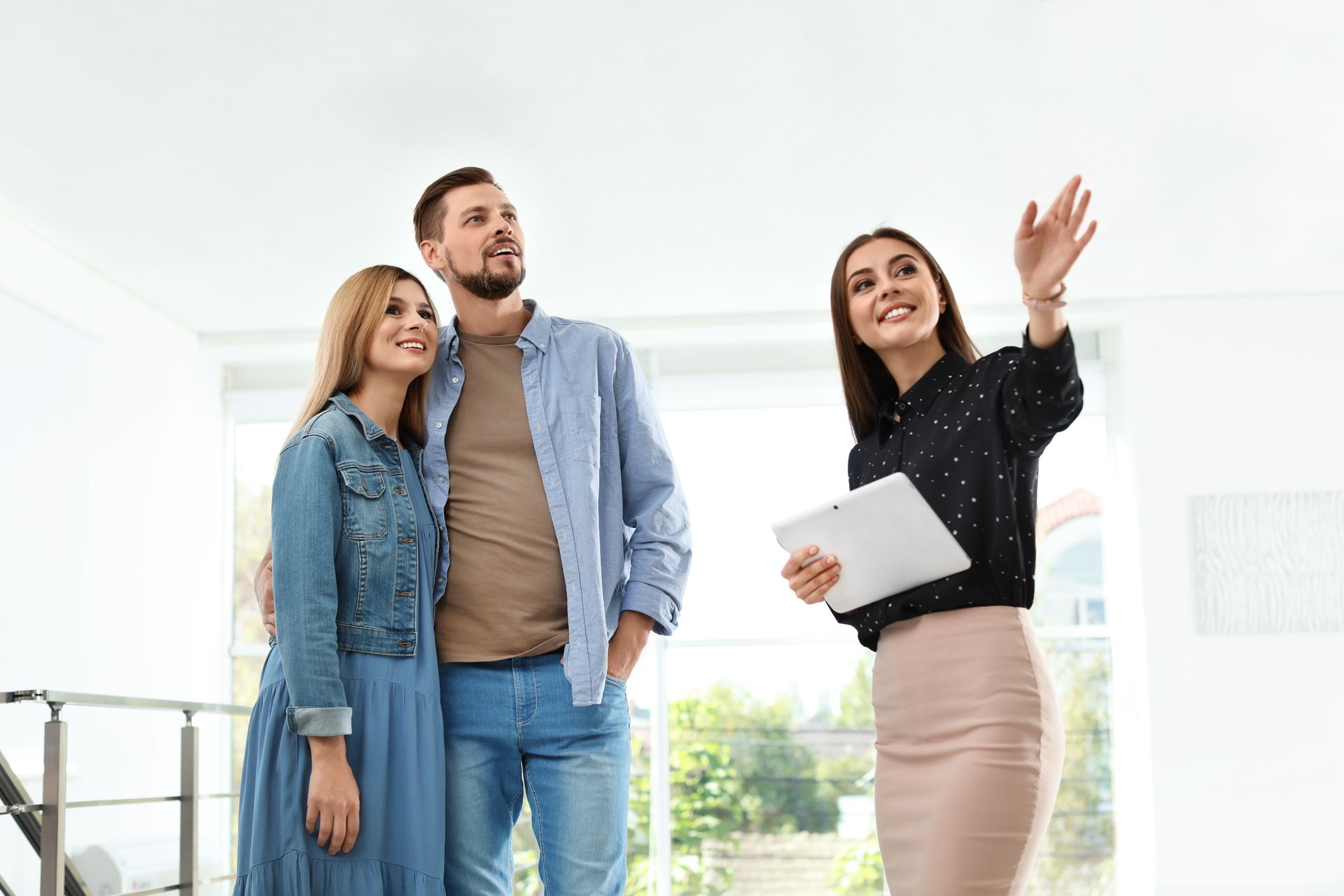 Real estate broker showing new house to couple. Real estate broker showing new house to couple.
