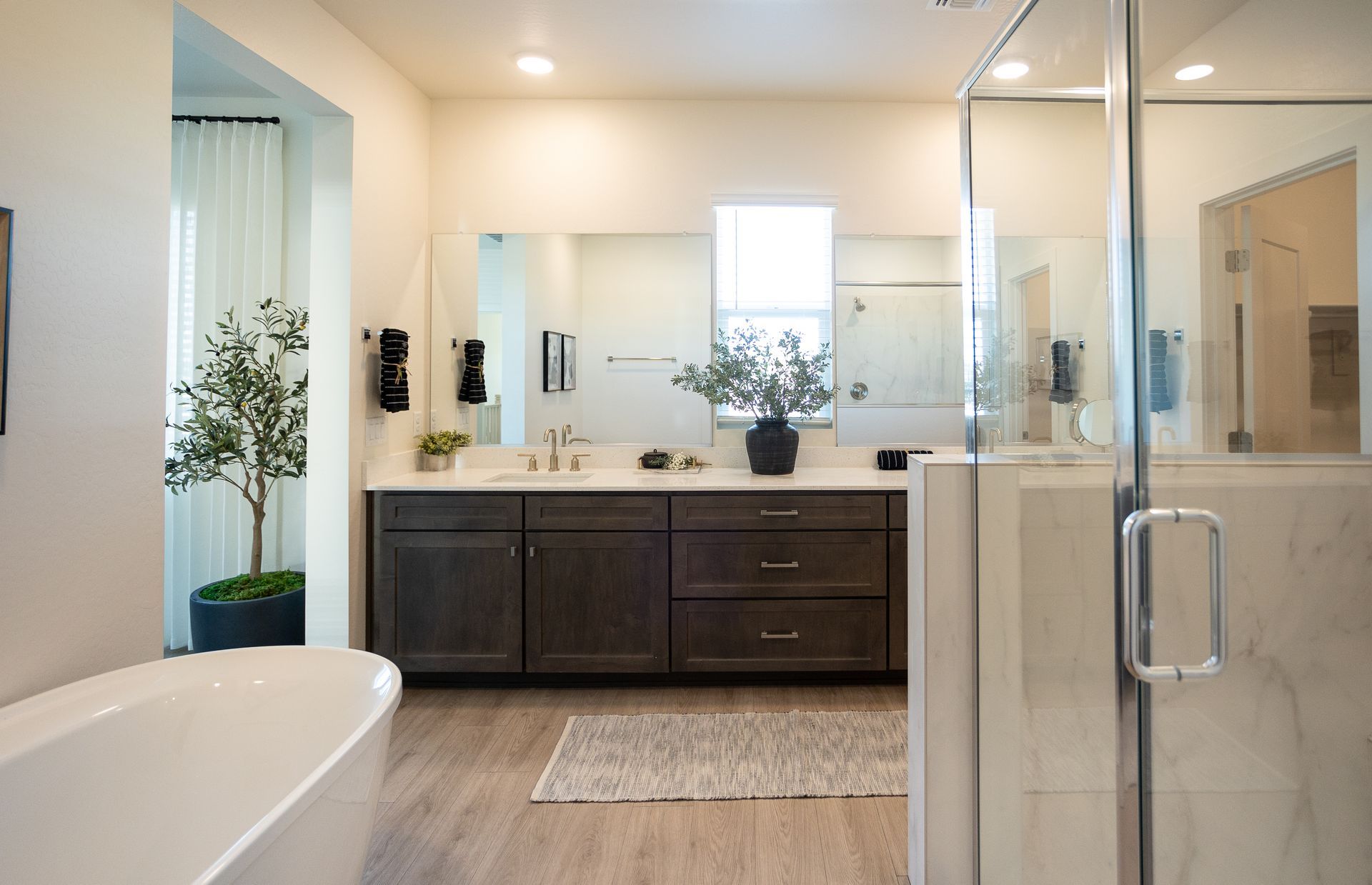 Modern bathroom with double vanity, glass shower, and freestanding tub