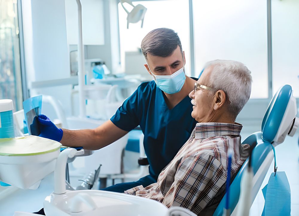 A Dentist is Talking to an Older Man in a Dental Chair — Dentist On Tweed in Tweed Heads, NSW