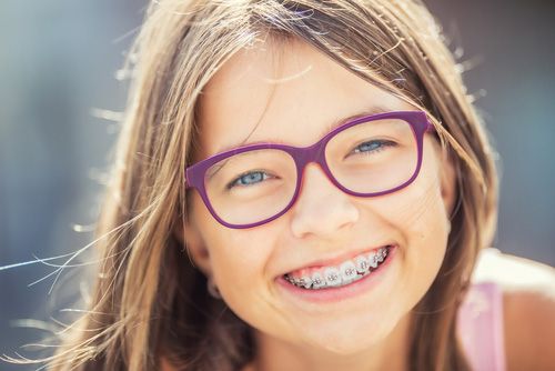 Young Girl Wearing Glasses And Braces Smiling — Dentist On Tweed in Tweed Heads, NSW