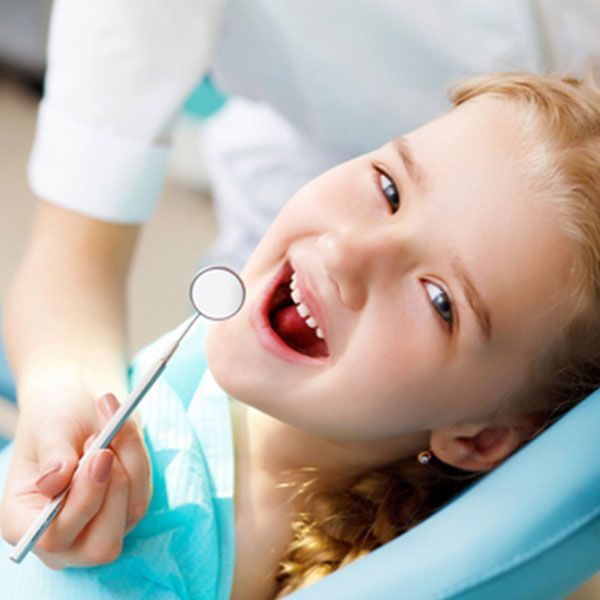 A Little Girl Is Getting Her Teeth Examined By A Dentist — Dentist On Tweed in Tweed Heads, NSW