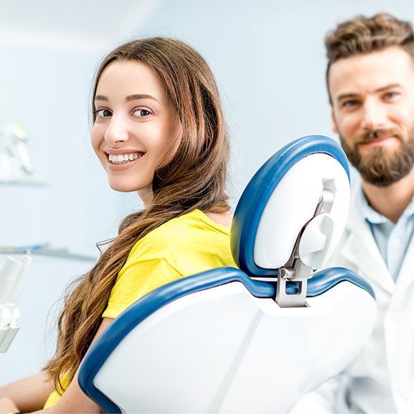 Woman Sitting In A Dental Chair Next To A Dentist — Dentist On Tweed in Tweed Heads, NSW