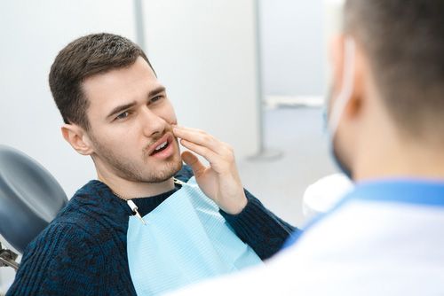 Man Sitting In A Dental Chair With A Toothache Emergency — Dentist On Tweed in Tweed Heads, NSW