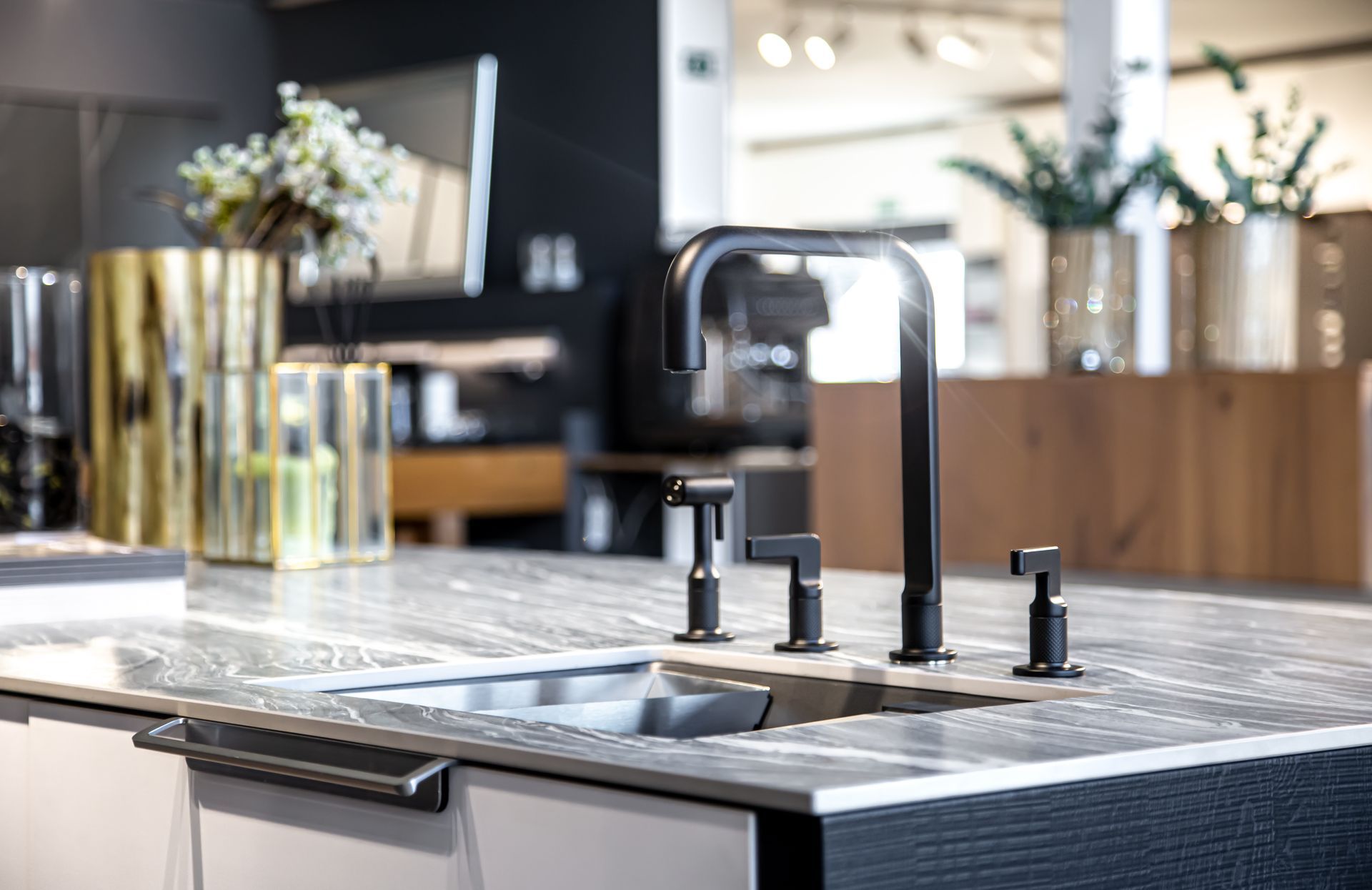 A kitchen counter with a sink and a bowl of fruit on it