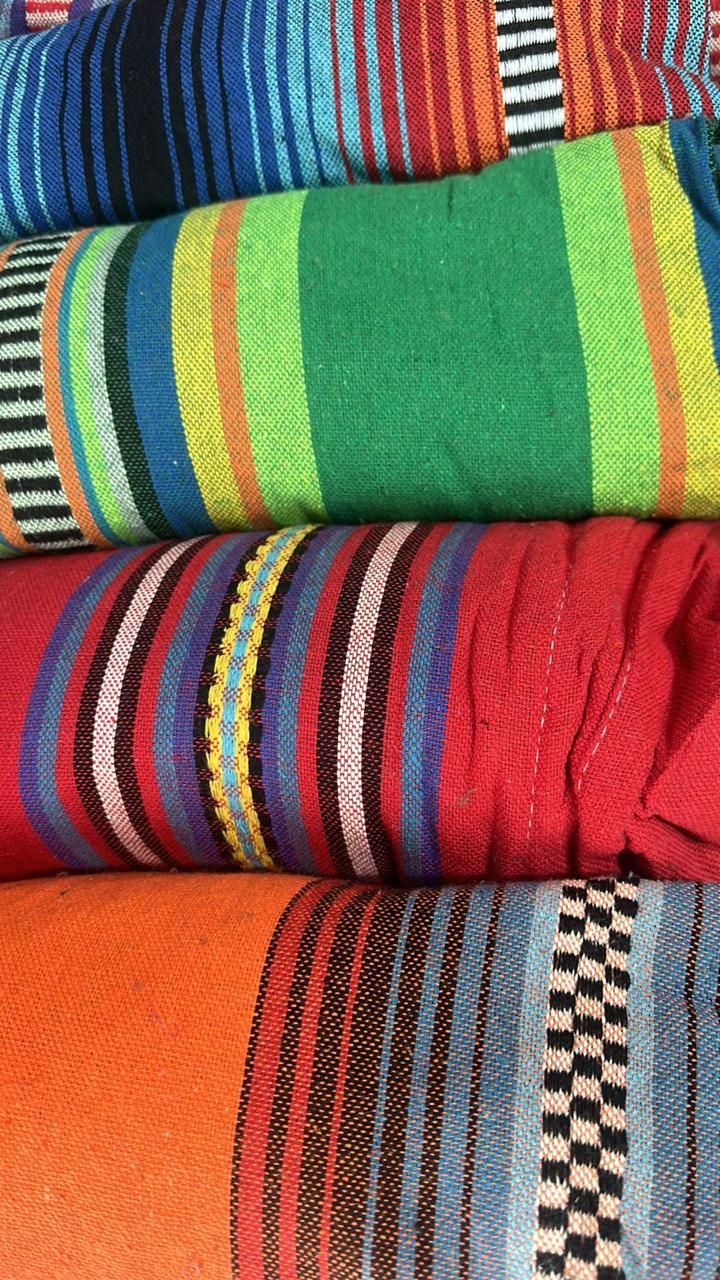 Cuatro mantas dobladas, de colores vivos y estilo mexicano