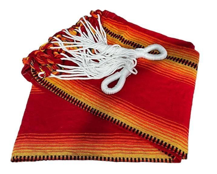 Una manta doblada de estilo mexicano, a rayas rojas, naranjas y amarillas