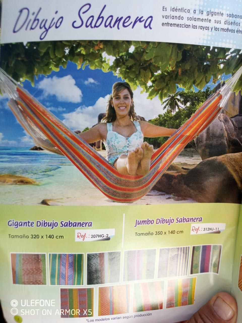Una mujer descansa en una hamaca colorida de rayas en la playa.