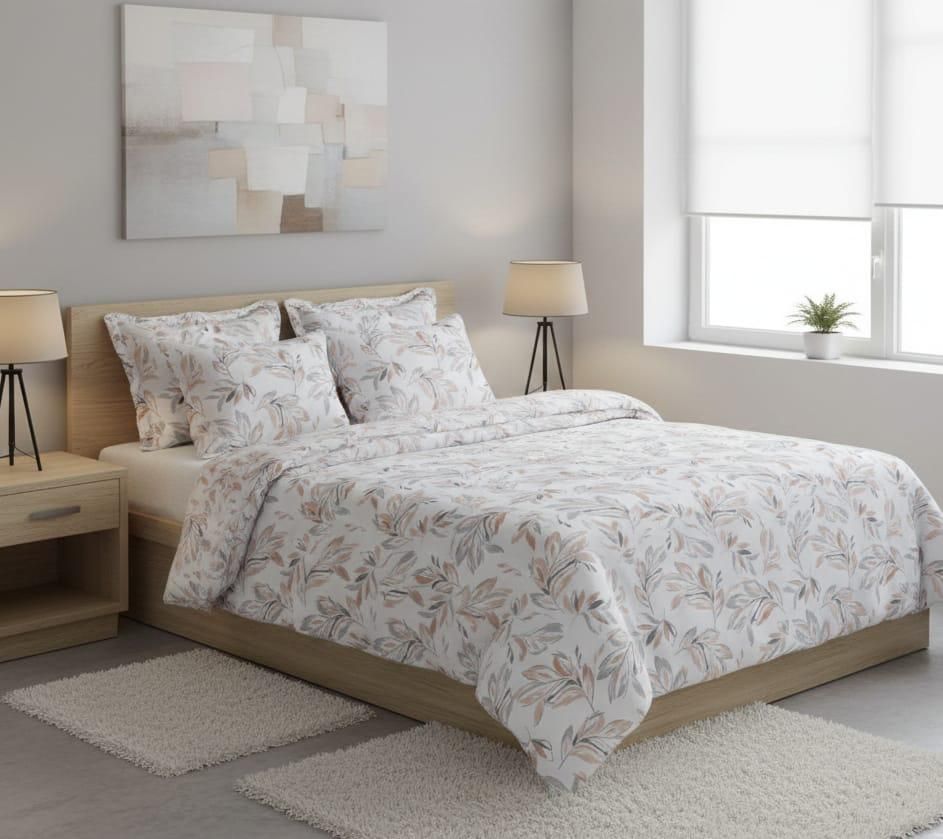 Una cama con ropa de cama blanca con un delicado estampado de hojas 