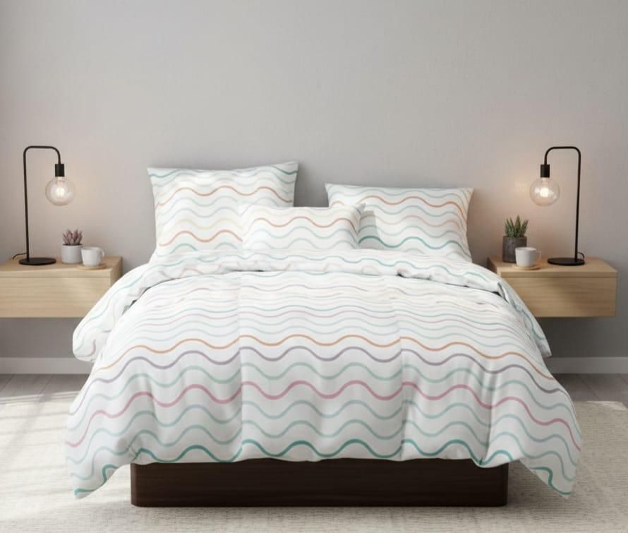 Una cama con ropa de cama blanca con coloridas rayas onduladas