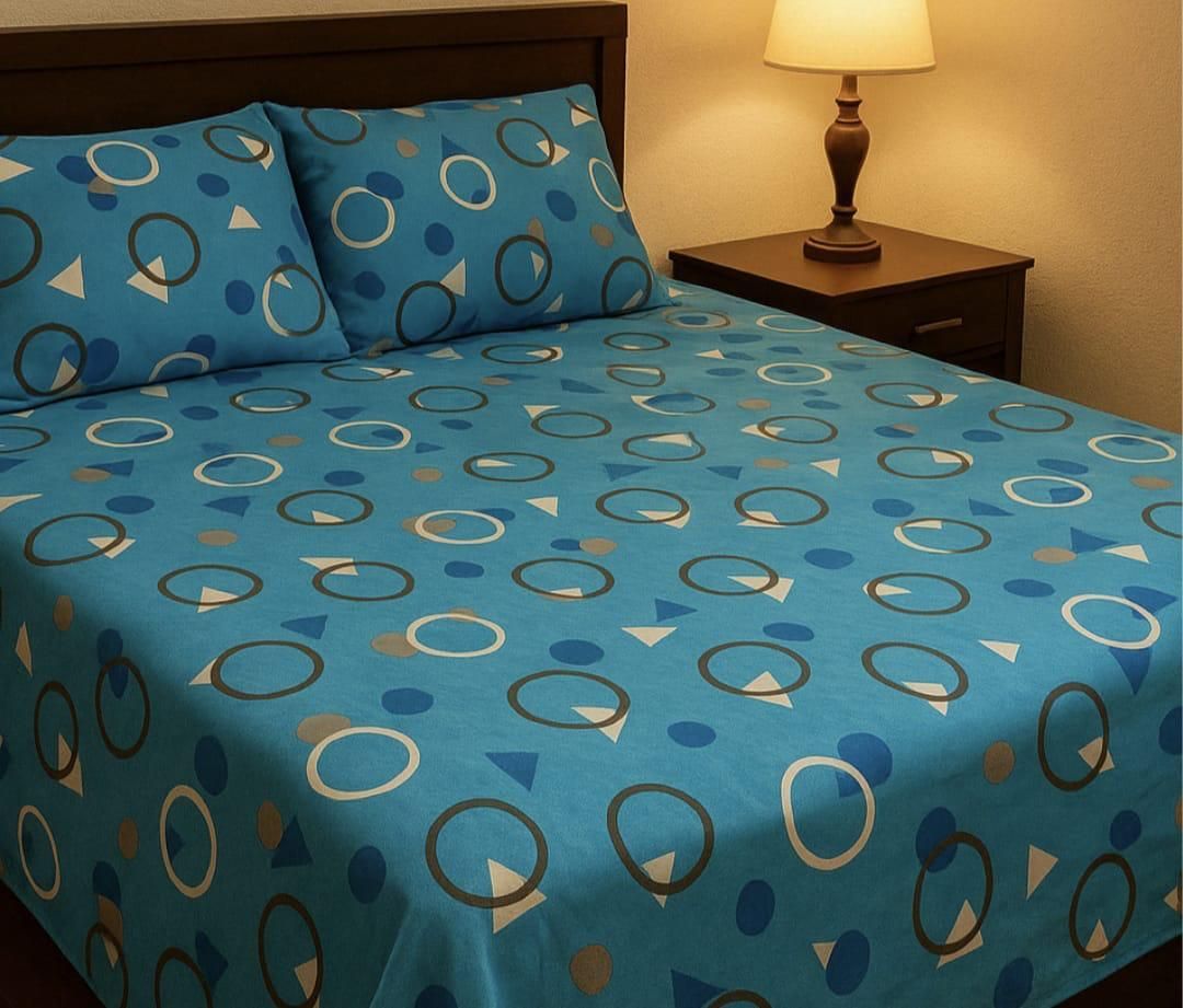 Un juego de cama azul con un estampado de círculos oscuros y triángulos claros