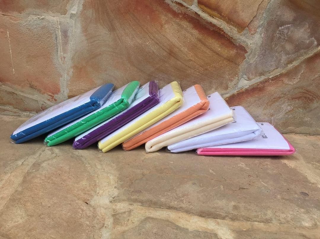 Una hilera de servilletas de tela de colores, dobladas, se alineaban sobre una superficie de piedra.