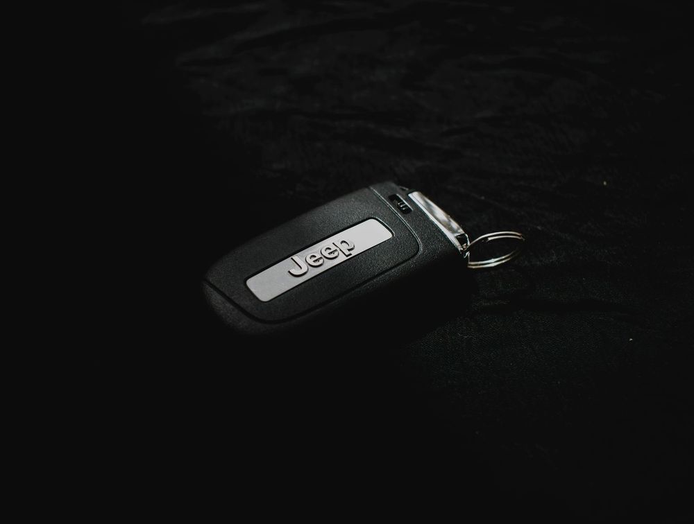 Black Jeep car key on a black surface.