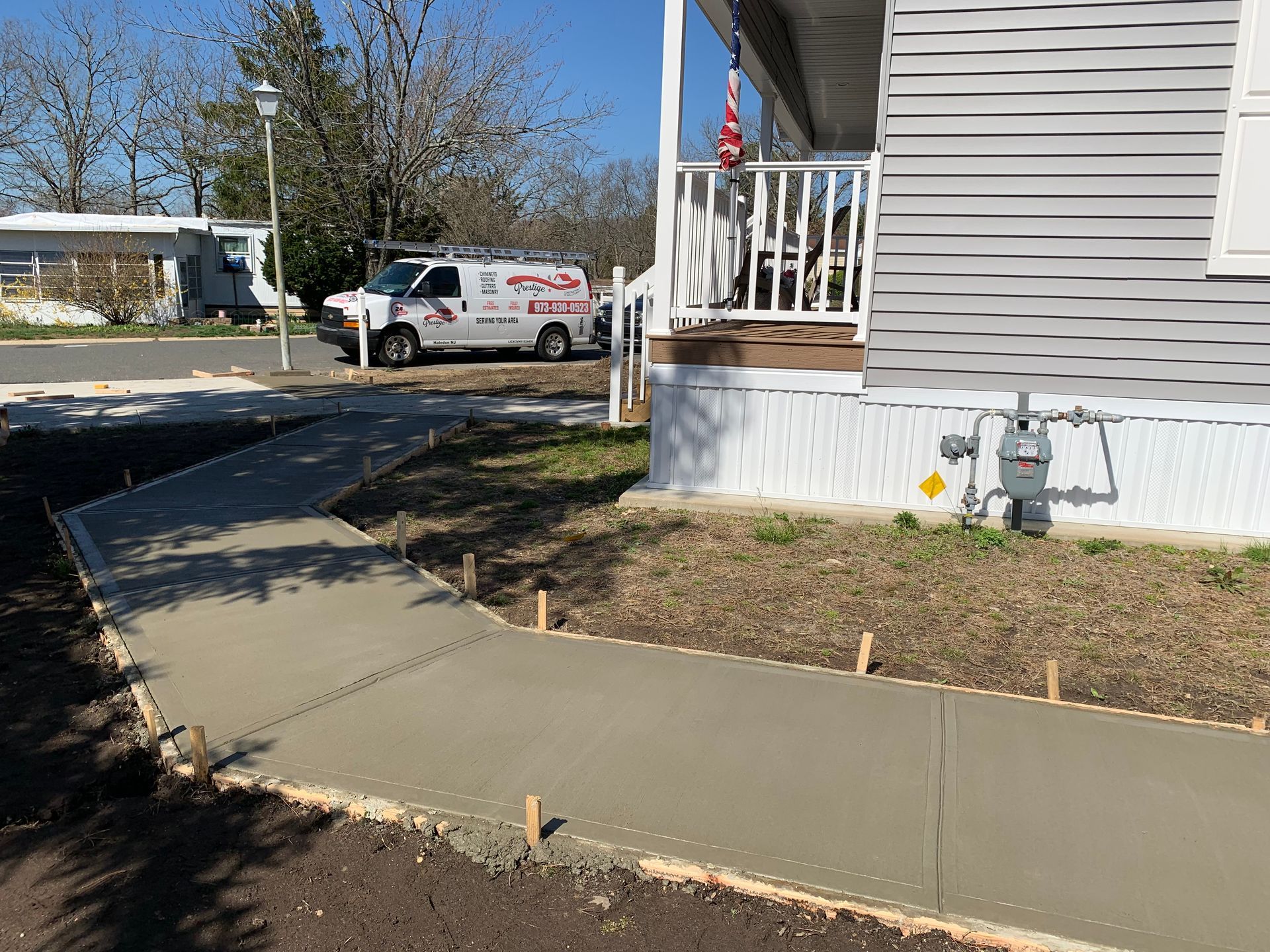 A concrete walkway is being built in front of a mobile home.