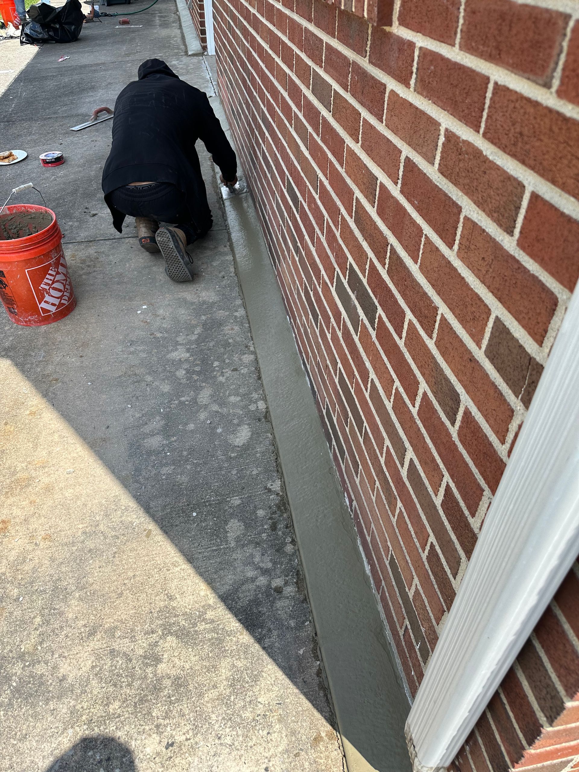 A man is working on the side of a brick building.