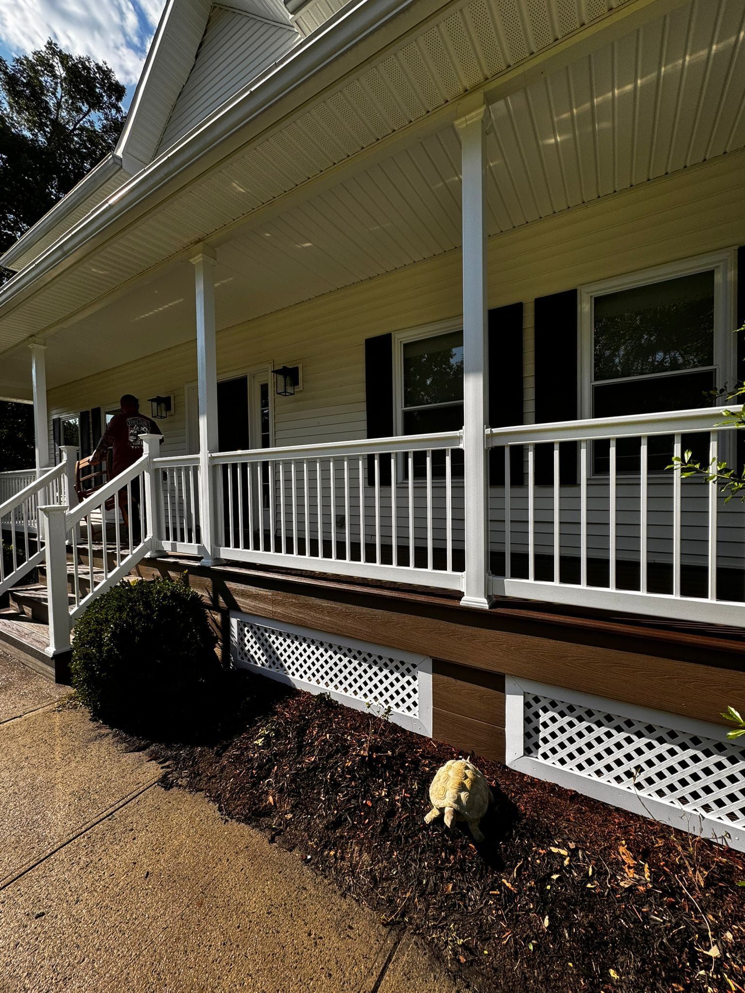 A white house with a porch and black shutters