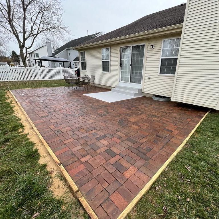 A house with a brick patio in front of it.