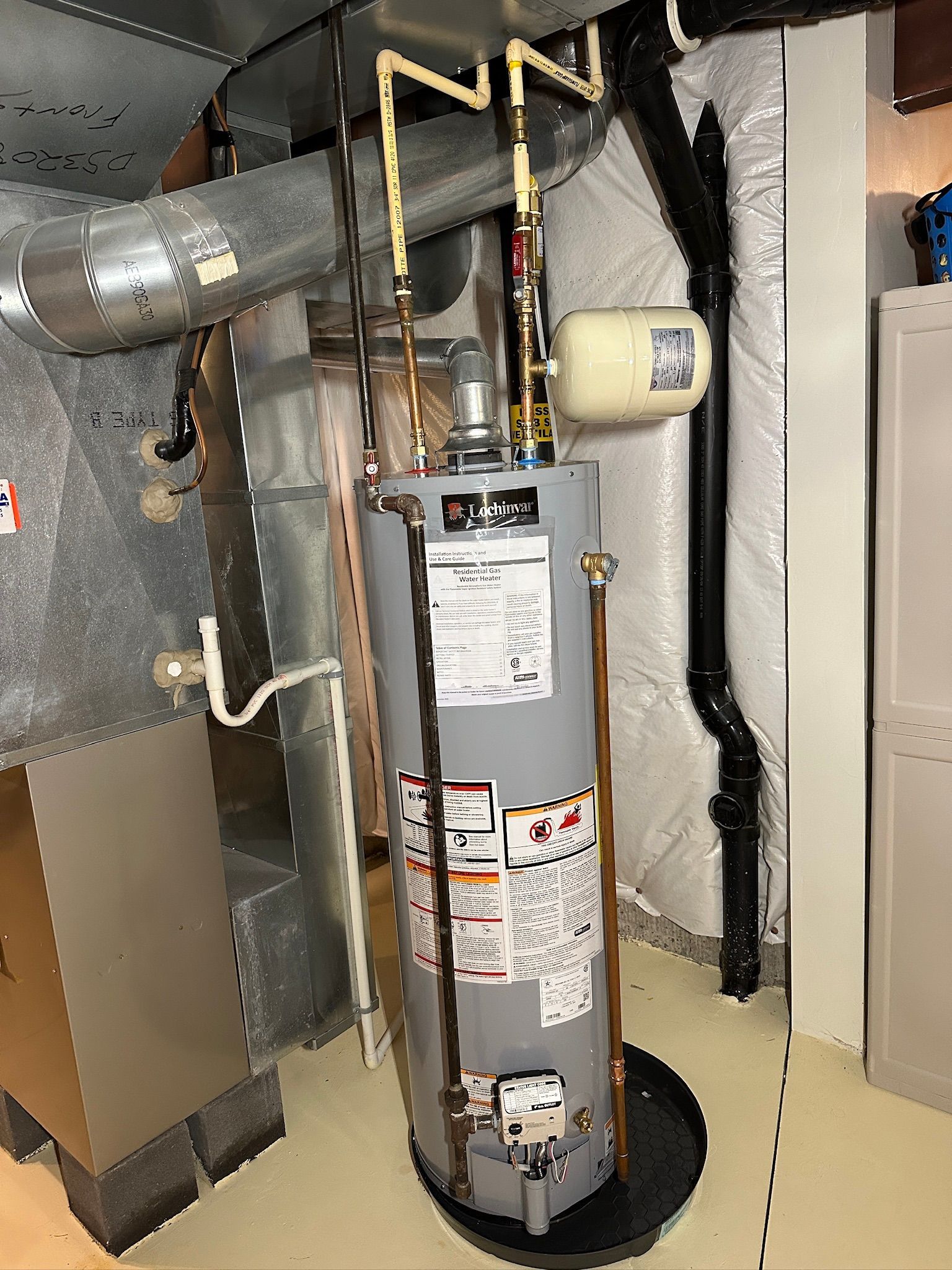 Hands adjusting a boiler’s control panel with a screwdriver and wire in a utility room