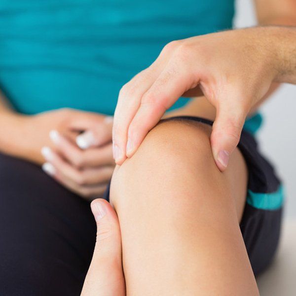 Physiotherapist treating patients knee