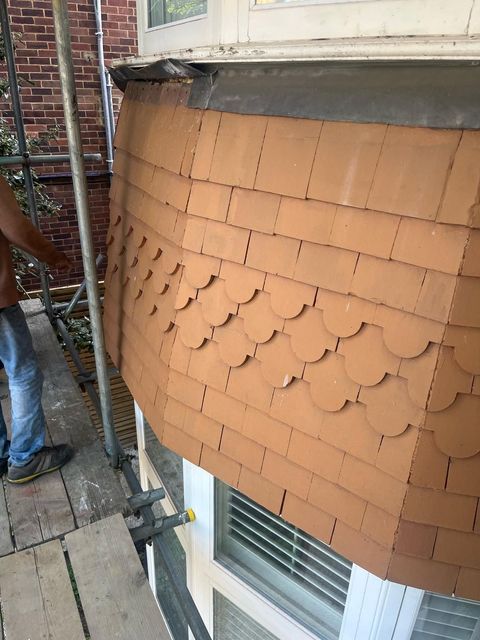 Detailed installation of scallop roof tiles by a roofer in Wimbledon.