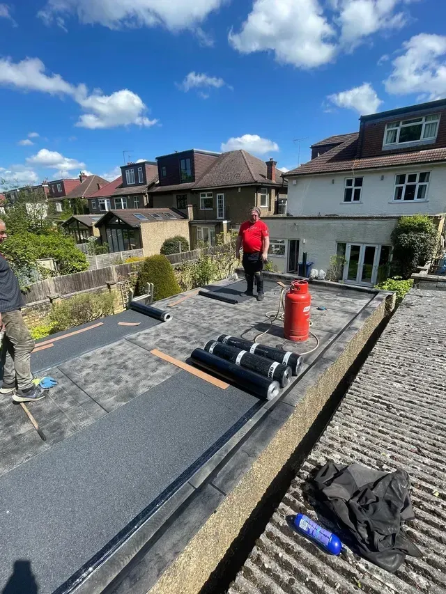 Roofers in Wimbledon installing new felt on a flat roof