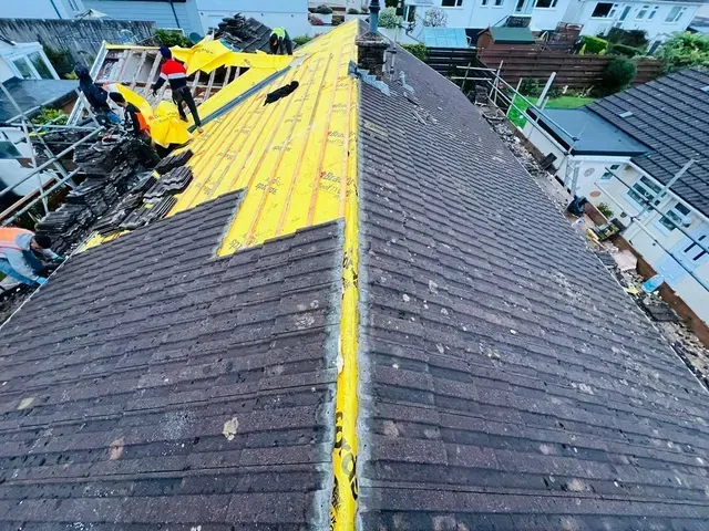 Wimbledon roofer undertaking a full roof replacement with old and new sections visible.