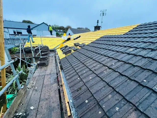 Roofers in Wimbledon preparing a roof for new underlay and tiles.
