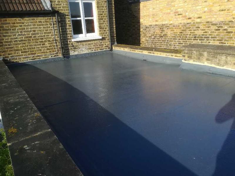 Newly installed flat roof with grey waterproofing by a roofer in Wimbledon.
