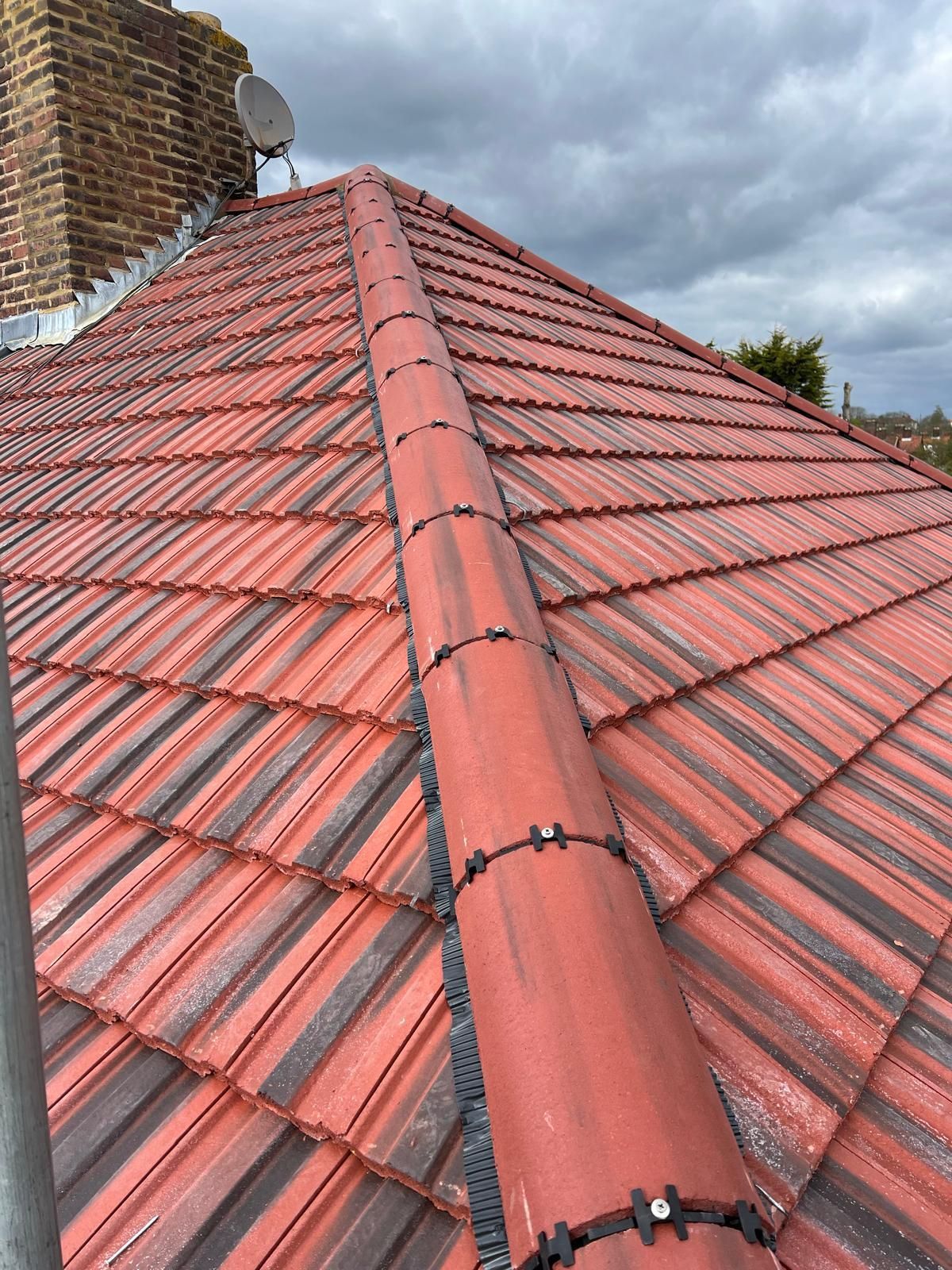 Newly installed red tiled roof with a modern dry-fix ridge system by a roofer in Wimbledon.