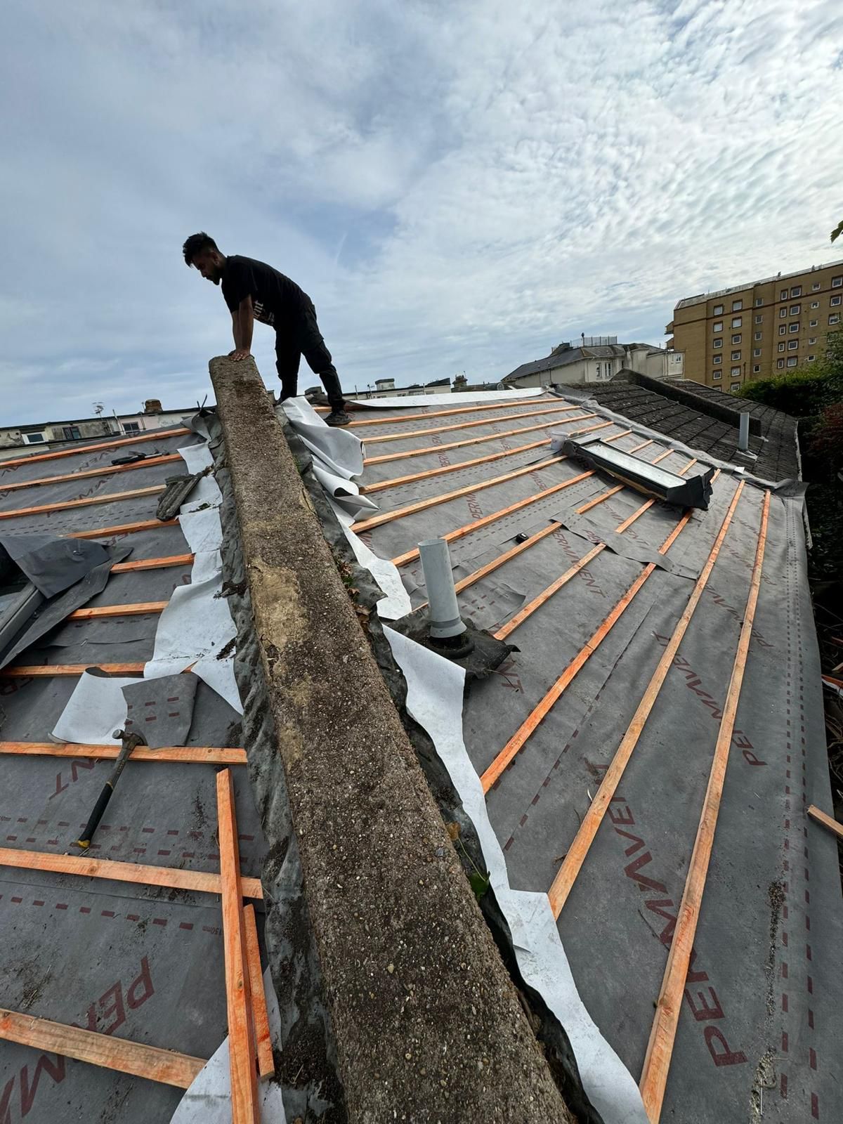 Roofer in Wimbledon installing new roof battens and underlay.