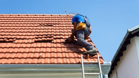 Wimbledon roofer working on a residential roof in sunny weather.