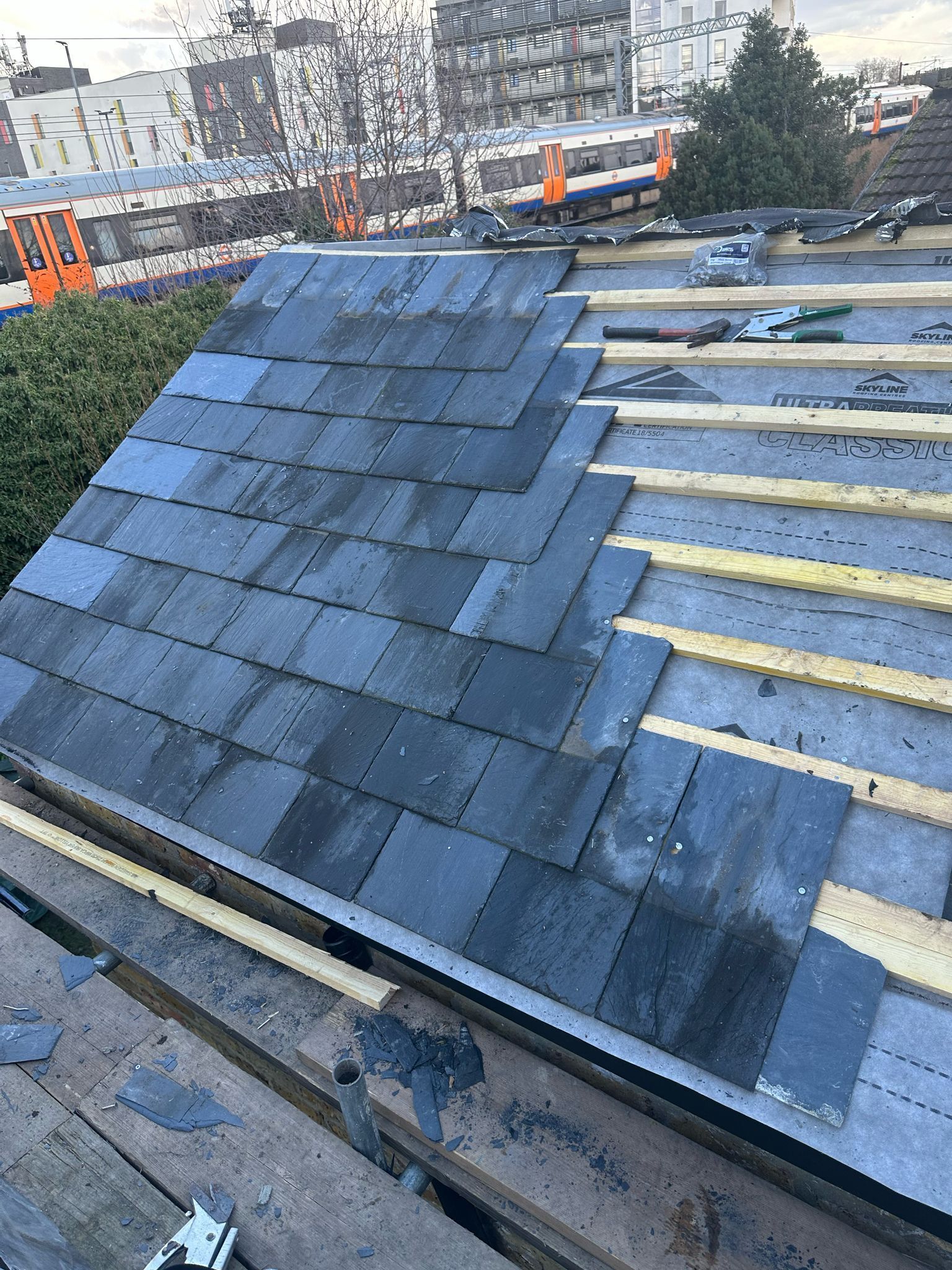 A roof is being built with slate tiles by roofer in Wimbledon D&R Roofing