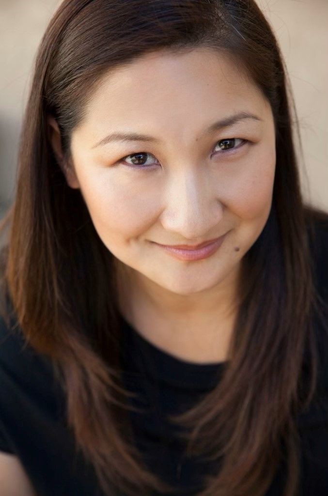 The woman is wearing a black shirt and smiling for the camera.