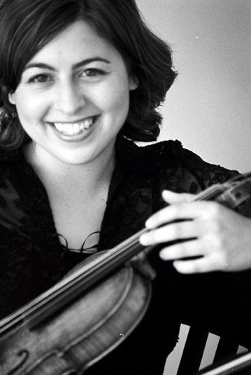 A black and white photo of a woman holding a violin