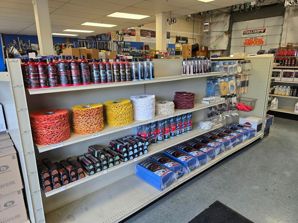 Shelves stocked with automotive supplies in a store; various colors, products displayed.