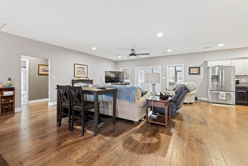 Spacious open-concept dining and living room with hardwood floors, gray walls, and modern furniture