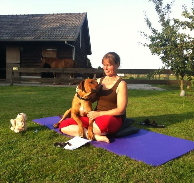Hond Joep zit lekker op schoot op de yogamat.