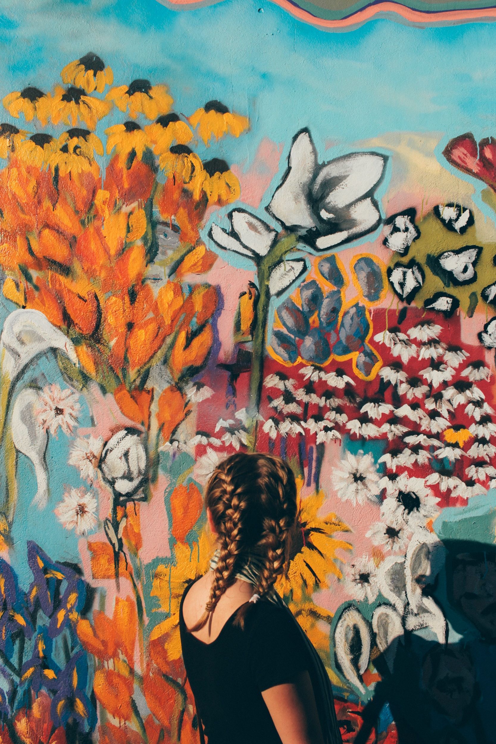 Photo of a girl observing colorful art painting