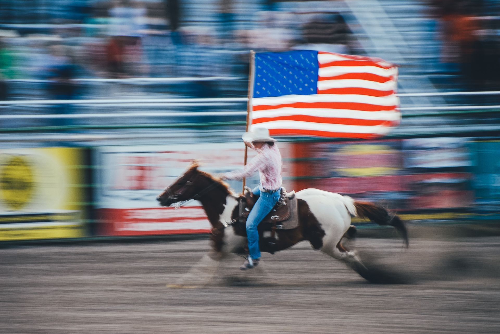 A woman is riding a horse while holding an American flag at the Wilson County fair in Lebanon, TN.